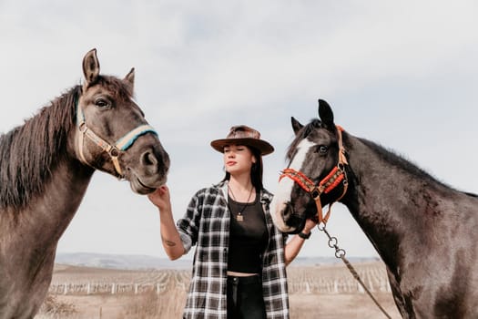 Cute happy young woman with horse. Rider female drives her horse in nature on evening sunset light background. Concept of outdoor riding, sports and recreation.