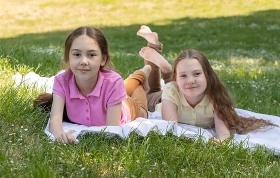 Joyful Little Children Enjoys Summer Time, School Break Lying On Grass In Meadow, Park At Sunny Day. Siblings Love, Having Fun In Nature. True Friendship. Horizontal Plane. High Quality Photo