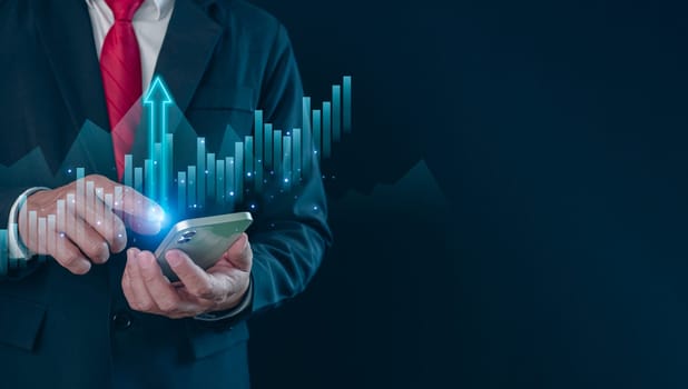 Hologram image of a candlestick chart from a phone on businessman hand. Offer trading, investment ideas