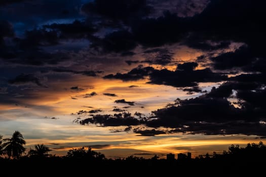 Panorama Cityscape at sunset with large river at foreground and strom clouds at background in Thailand.