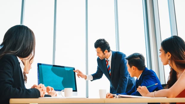 Business people in the conference room with green screen chroma key TV or computer on the office table. Diverse group of businessman and businesswoman in meeting on video conference call . Jivy