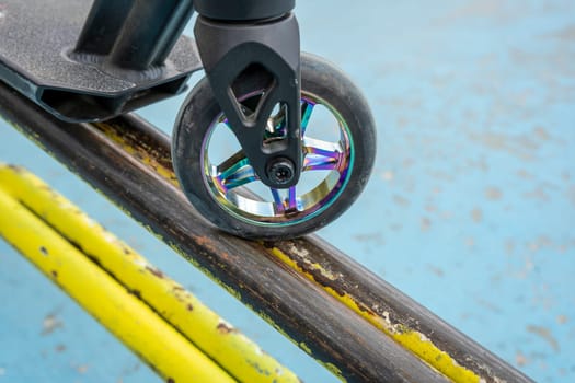 Stunt scooter on the yellow iron tube ramp of the skate park. Jumps and tricks. extreme urban outdoor sports, Healthy lifestyle concept. sports leisure