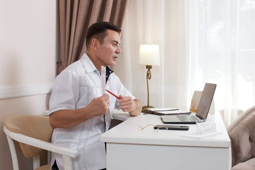 male doctor in white medical uniform using computer laptop in health clinic or hospital. online consultation for domestic health treatment