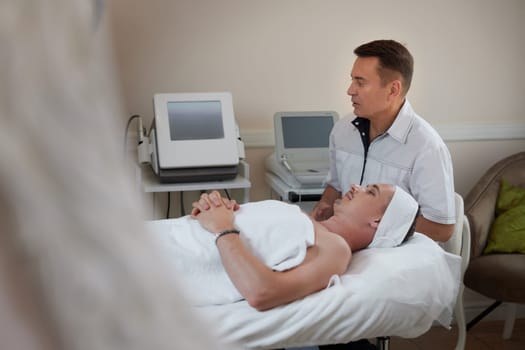 handsome man on RF lifting procedure in aesthetic medicine clinic