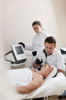 handsome man on RF lifting procedure in aesthetic medicine clinic