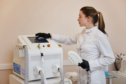 female cosmetologist doctor with laser, hair removal with modern equipment