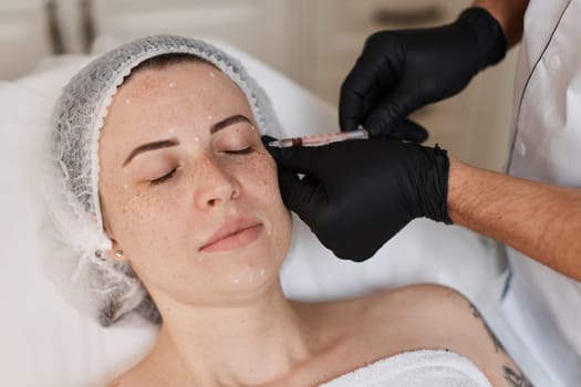 woman receives cosmetic botox injection in face. Woman in beauty salon. plastic surgery.