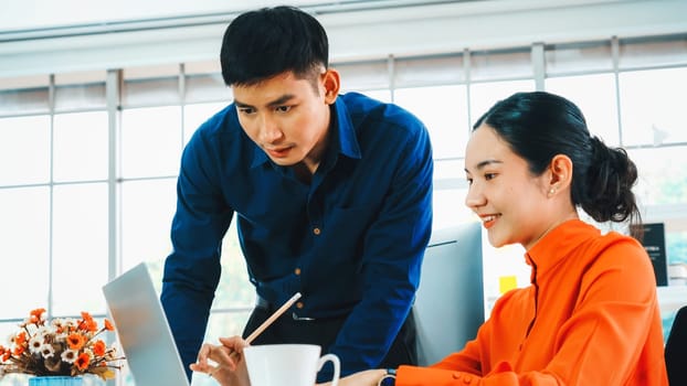 Two business people talk project strategy at office meeting room. Businessman discuss project planning with colleague at modern workplace while having conversation and advice on financial report. Jivy