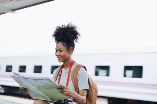 Asian teenage girl african american traveler dressed in casual wear holding map and searching right direction of route