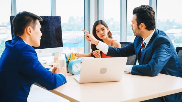 Smart businessman and businesswoman talking discussion in group meeting at office table in a modern office interior. Business collaboration strategic planning and brainstorming of coworkers. Jivy