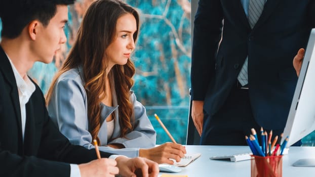 Smart businessman and businesswoman talking discussion in group meeting at office table in a modern office interior. Business collaboration strategic planning and brainstorming of coworkers. Jivy