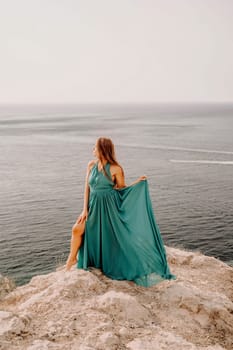 Woman sea green dress. Side view a happy woman with long hair in a long mint dress posing on a beach with calm sea bokeh lights on sunny day. Girl on the nature on blue sky background