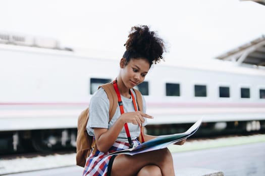 Asian teenage girl african american traveler dressed in casual wear holding map and searching right direction of route