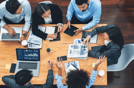 Top view multiracial analyst team use BI dashboard display on laptop screen, analyzing financial data for strategic decision. Fintech analyzes marketing indicators. Concord