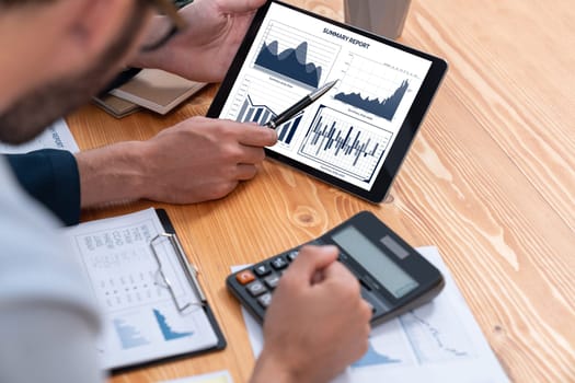 Busy analyst team in office analyzing financial data analysis for marketing strategy in workspace using BI dashboard with graph and chart on tablet screen to improve business performance. Entity