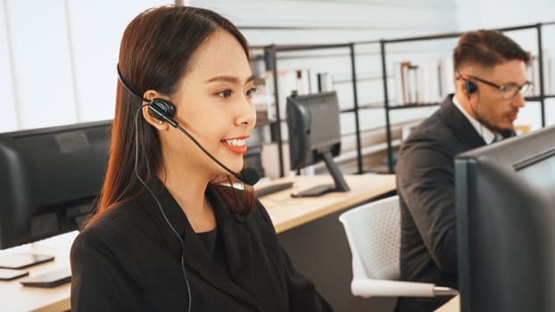 Business people wearing headset working in office to support remote customer or colleague. Call center, telemarketing, customer support agent provide service on telephone video conference call. Jivy