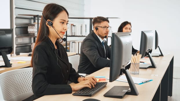 Business people wearing headset working in office to support remote customer or colleague. Call center, telemarketing, customer support agent provide service on telephone video conference call. Jivy