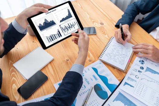 Busy analyst team in office analyzing financial data analysis for marketing strategy in workspace using BI dashboard with graph and chart on tablet screen to improve business performance. Entity