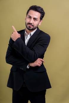 Confident businessman in formal suit pointing finger up to indicate promotion or advertising with excited and amazed facial expression and gesture on isolated background. Fervent