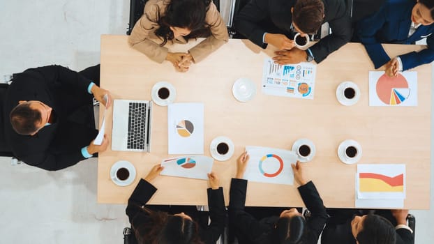 Business people group meeting shot from top view in office . Profession businesswomen, businessmen and office workers working in team conference with project planning document on meeting table . Jivy