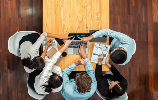 Panorama top view diverse group of business analyst team analyzing financial data report paper on meeting table. Chart and graph dashboard by business intelligence analysis. Meticulous