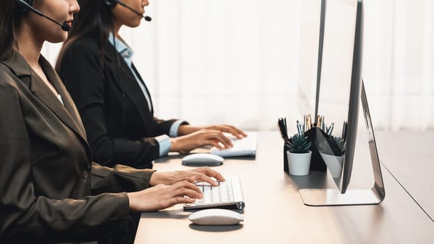 Panorama call center operator team or telesales representative siting at office desk wearing headset and engaged in conversation with client providing customer service support or making sales. Prodigy