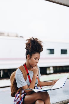 Asian teenage girl african american traveler dressed in casual wear holding map and searching right direction of route