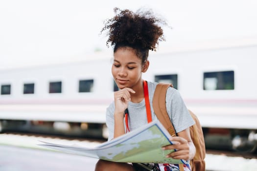 Asian teenage girl african american traveler dressed in casual wear holding map and searching right direction of route