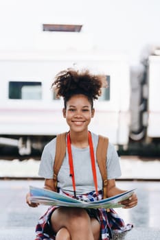 Asian teenage girl african american traveler dressed in casual wear holding map and searching right direction of route