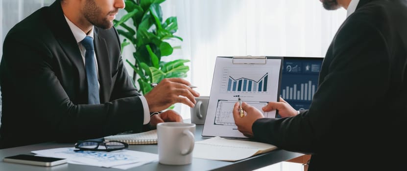 Busy analyst team discussing financial data on digital dashboard, analyzing chart and graph using data science software display on a laptop screen. Business intelligence and Fintech. Fervent