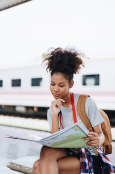 Asian teenage girl african american traveler dressed in casual wear holding map and searching right direction of route