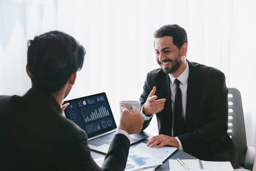 Busy analyst team discussing financial data on digital dashboard, analyzing chart and graph using data science software display on a laptop screen. Business intelligence and Fintech. Fervent