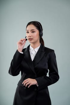 Attractive asian female call center operator with happy smile face advertises job opportunity on empty space, wearing a formal suit and headset on customizable isolated background. Enthusiastic