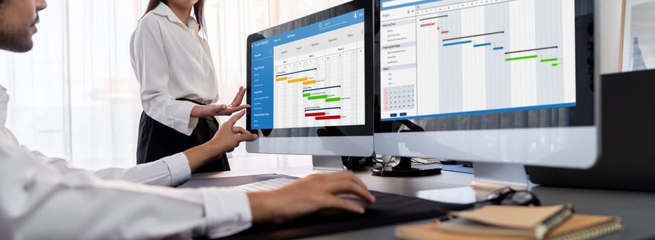 Project management team coordinating and update project planned schedule on computer using Gantt chart software in office. Business people planning time and deadline for company task. Trailblazing