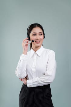 Attractive asian female call center operator with happy smile face advertises job opportunity on empty space, wearing a formal suit and headset on customizable isolated background. Enthusiastic