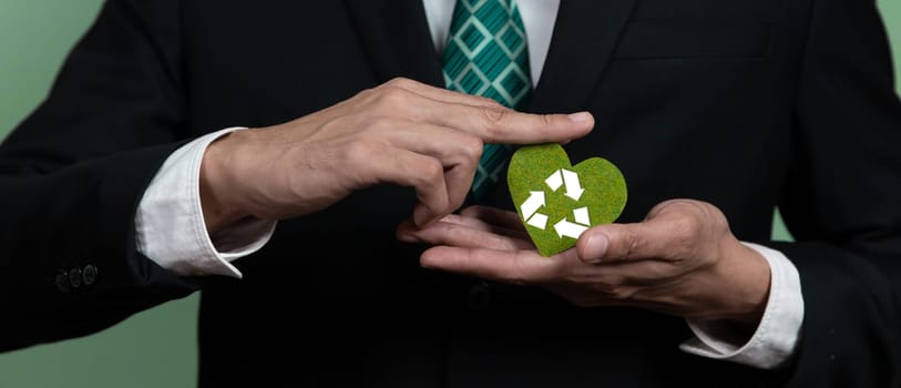 Corporate promoting sustainable and green business concept with businessman holding Recycle symbol paper as Reduce Reuse Recycle concept for waste management for clean environment idea. Alter