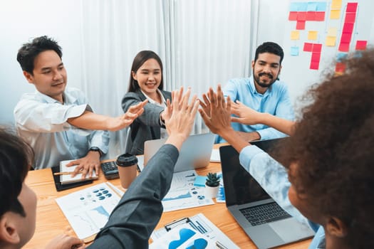 Diverse business team celebrate successful meeting with high-fives and expressions of happiness in corporate office meeting represent unity success and professional integrity. Concord