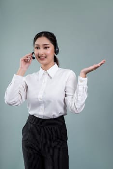 Asian female call center operator with smile face advertises job opportunity, wearing a formal suit and headset holding hand gesture for product on customizable isolated background. Enthusiastic