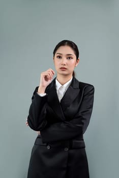Confident young businesswoman stands on isolated background, posing in formal black suit. Office lady or manager with smart and professional appearance. Enthusiastic