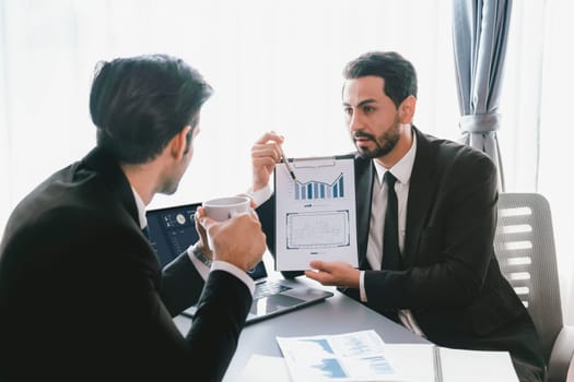 Busy analyst team discussing financial data on digital dashboard, analyzing chart and graph using data science software display on a laptop screen. Business intelligence and Fintech. Fervent