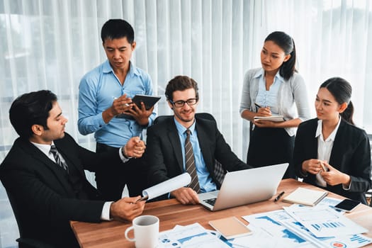 Diverse group of business analyst team analyzing financial data report paper on office table. Chart and graph dashboard by business intelligence analysis for strategic marketing planning Meticulous