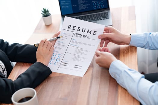 Conversational job interview between interviewer and candidate. Asian female job applicant present her performance and qualification by digital resume on laptop and CV paper to HR manager. Jubilant