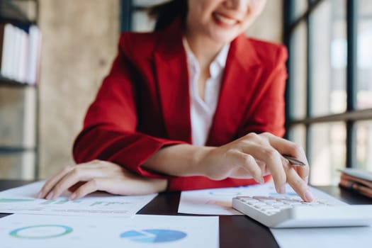 Young asian female work with financial papers at home count on calculator before paying taxes receipts online, planning budget glad to find chance for economy saving money, audit concepts.