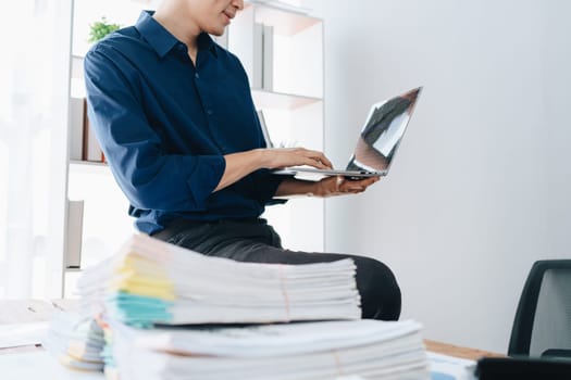 Businessman using computer laptop with planning working on financial document, tax, exchange, accounting and Financial advisor