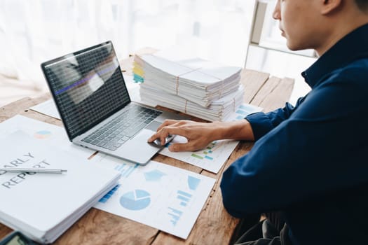 Businessman using computer laptop with planning working on financial document, tax, exchange, accounting and Financial advisor