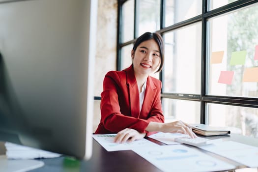 Young asian female work with financial papers at home count on calculator before paying taxes receipts online, planning budget glad to find chance for economy saving money, audit concepts.