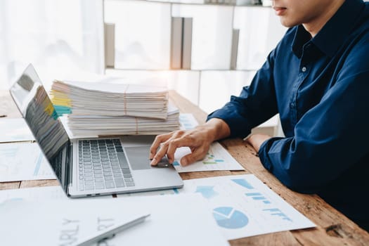 Businessman using computer laptop with planning working on financial document, tax, exchange, accounting and Financial advisor