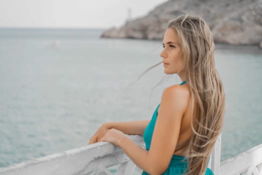 Woman sea green dress. Side view a happy woman with long hair in a long mint dress posing on a beach with calm sea bokeh lights on sunny day. Girl on the nature on blue sky background