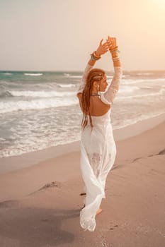 woman sea white dress. Model in boho style in a white long dress and silver jewelry on the beach. Her hair is braided, and there are many bracelets on her arms