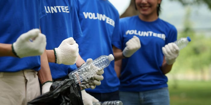 Young Asian Volunteers with garbage bags cleaning park area. Ecology, Charitable organization concept.